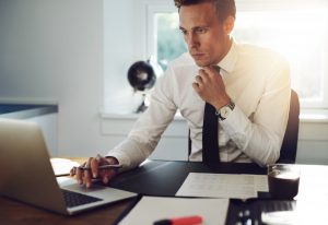 A paralegal examining his case on his laptop