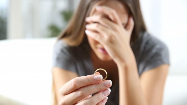 Divorcee holding a ring while crying