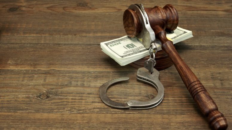 gavel, cash, and handcuffs on table